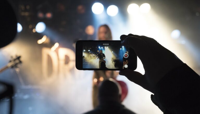 Person filmt mit Handy ein Rock-Konzert