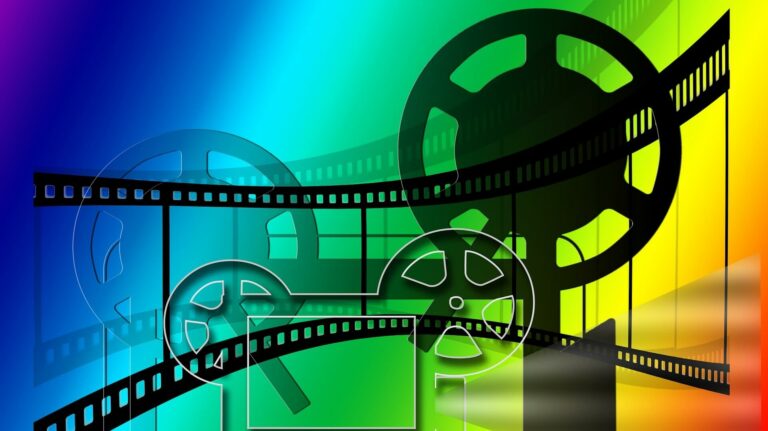 Filmspulen und Filmstreifen vor buntem Hintergrund