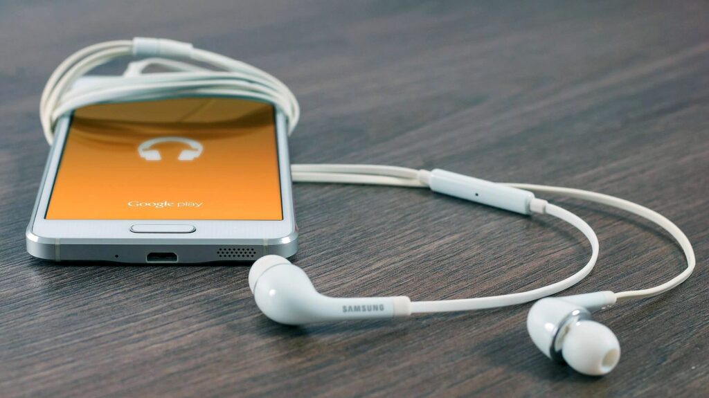 Smartphone und Kopfhörer liegen auf einem Tisch